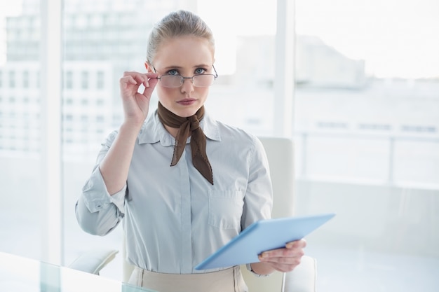 Blonde fronsende zakenvrouw met tablet