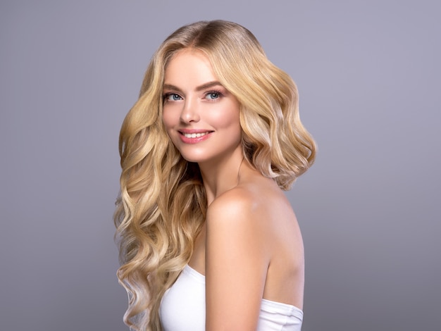 Blonde gezicht vrouw krullend haar schoonheid gezicht natuurlijke make-up. Studio opname.