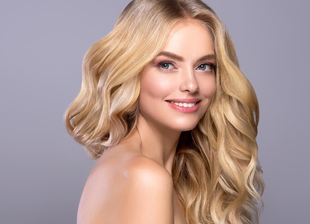 Blonde gezicht vrouw krullend haar schoonheid gezicht natuurlijke make-up. Studio opname.