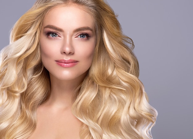 Blonde gezicht vrouw krullend haar schoonheid gezicht natuurlijke make-up. Studio opname.