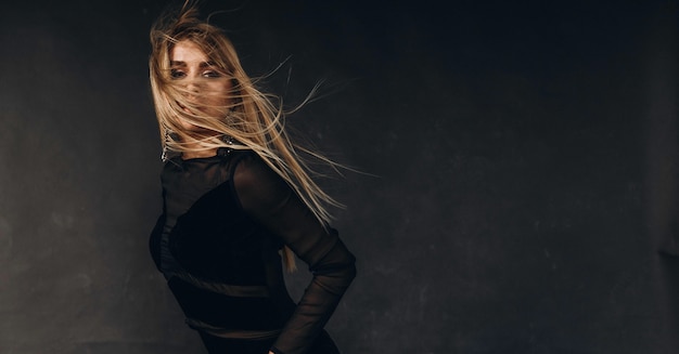 blonde girl in black dress posing