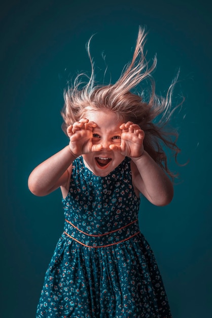 Blonde girl in flowery dress performs a scary face