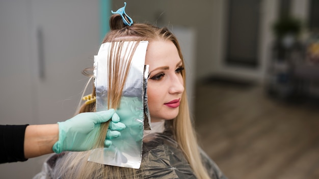 Photo blonde girl getting her hair dyeing