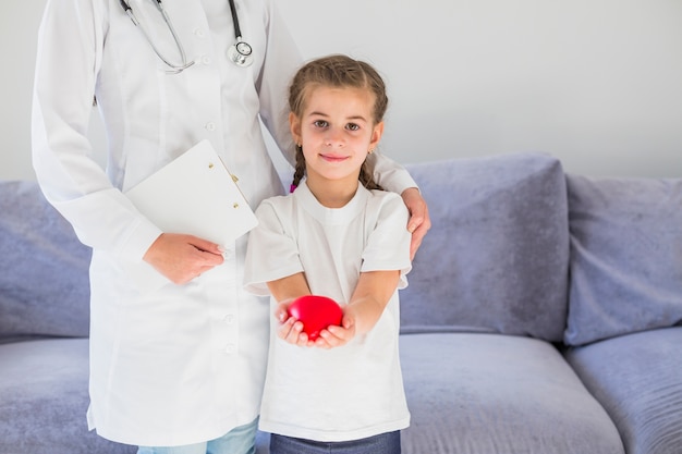 Ragazza bionda che tiene il cuore con il medico