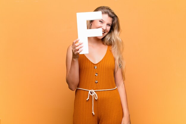 blonde girl holding the letter  f