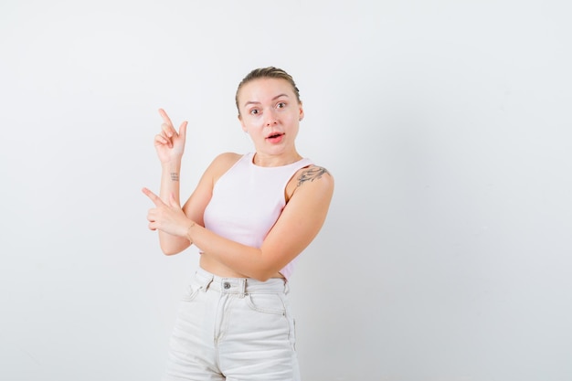 Blonde girl is showing her fingers on white background