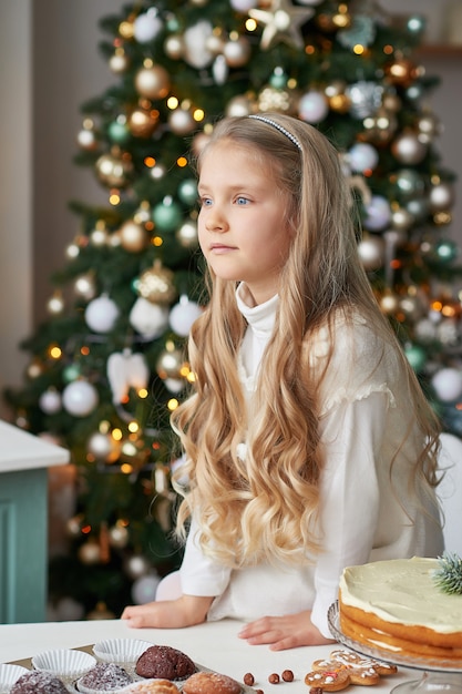 blonde girl in the new year's kitchen with cupcakes and sweets