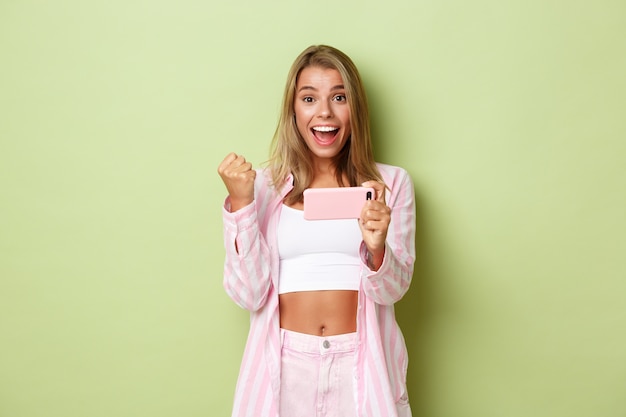 Blonde girl in a pink outfit posing