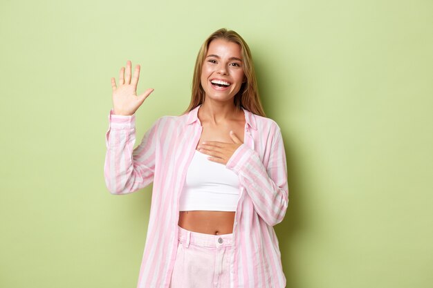 Blonde girl in a pink outfit posing