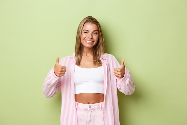 Blonde girl in a pink outfit posing