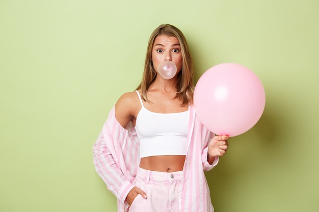 Blonde girl in a pink outfit posing