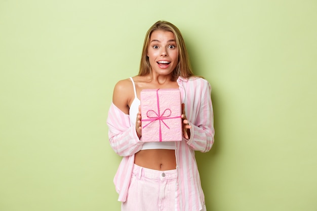 Blonde girl in a pink outfit posing