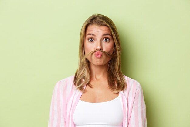 Blonde girl in a pink outfit posing