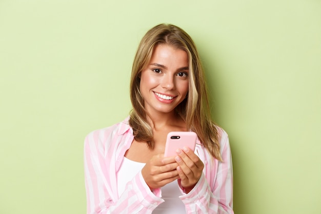 Blonde girl in a pink outfit posing