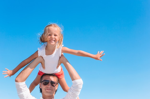 blonde girl playing with his father at the beach