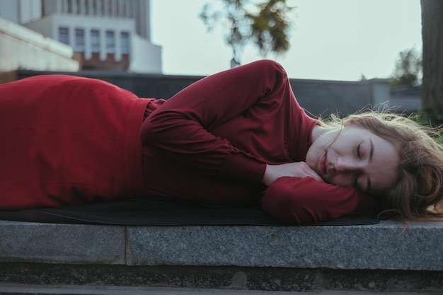빨간 옷을 입은 금발 소녀가 공원에 누워 있다