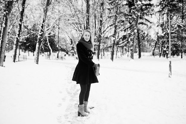 빨간 스카프와 코트 겨울 날에 공원에서 산책에 금발 소녀.