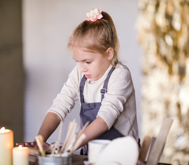 粘土からのブロンドの女の子の彫刻