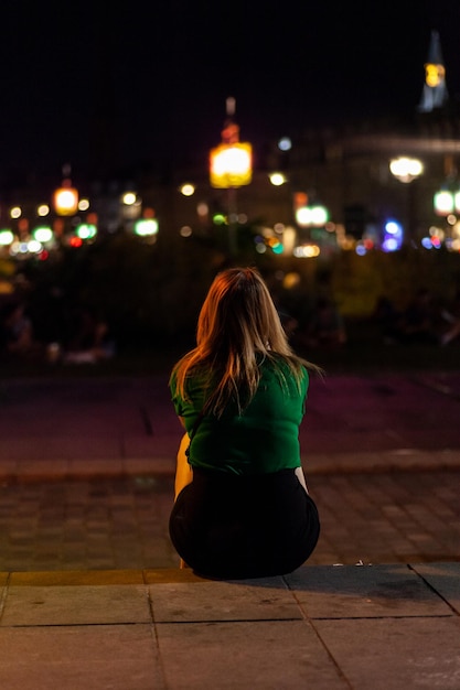 Blonde girl sitting on the sidewalk Bordeaux