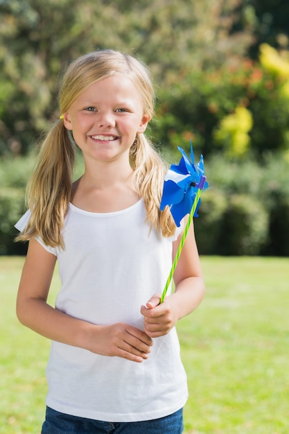 Blonde girl smiling and holding pinwheel
