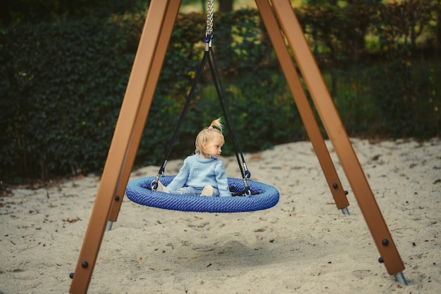 Blonde girl on the swing