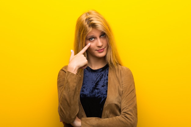 Blonde girl on vibrant yellow background looking to the front