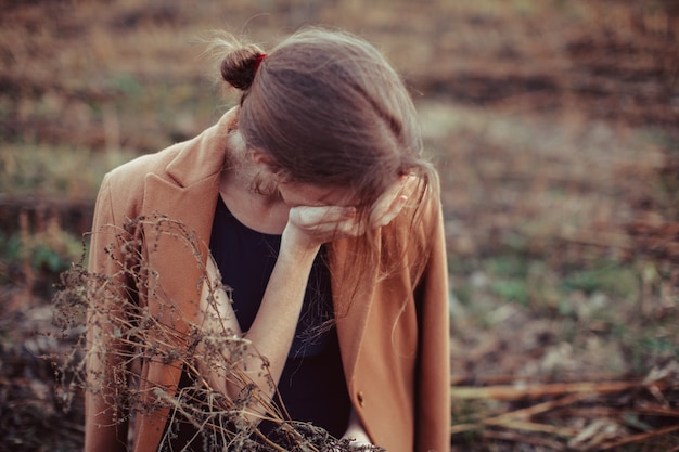 写真 ブロンドの女の子は荒れ地を孤独に歩きます。うつ病の概念