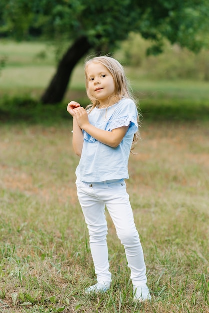 blonde girl wearing white jeans and a blue t-shirt