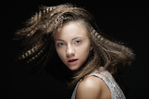 Blonde girl with curly hair Beautiful model woman with wavy hairstyle over black background