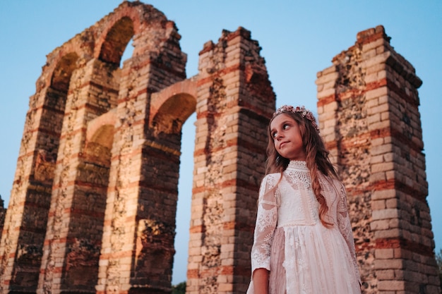 Blonde girl with curly hair dressed in communion dress in Merida