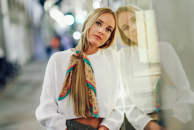 Blonde girl with defocused urban city lights at night