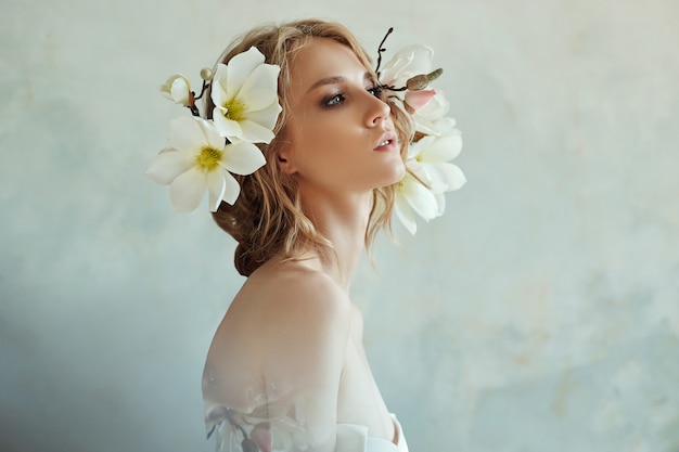 Ragazza bionda con fiori vicino al viso