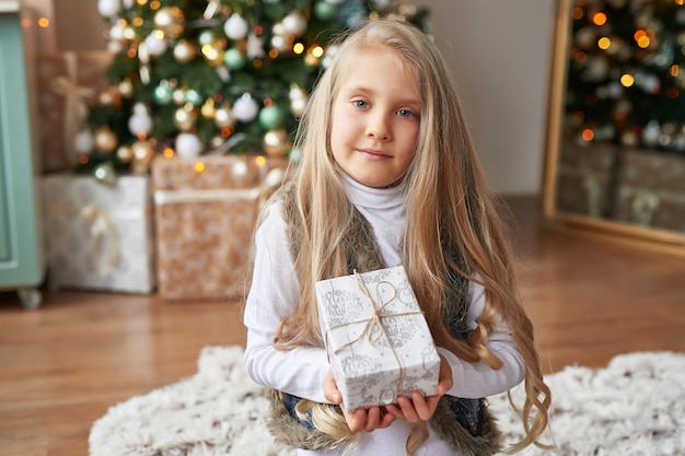 blonde girl with gifts in the New Year's interior