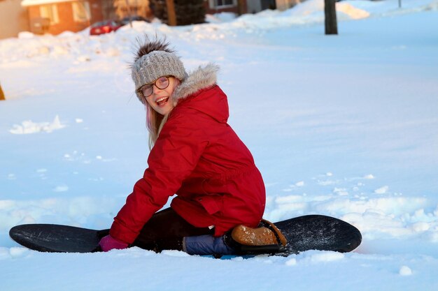 Блондинка в очках катается по снежным горкам зимой на закате