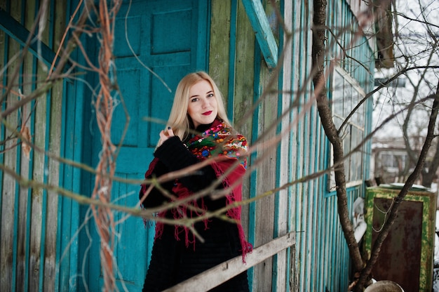 Blonde girl with hand embroidered scarf posed at winter day.