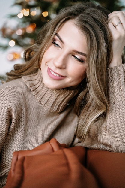 Blonde girl with long hair in a brown knitted dress