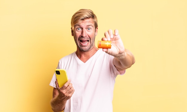 Blonde handsome adult man holding a batterie