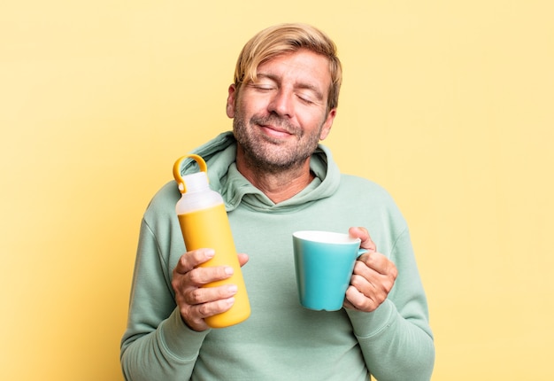 Blonde handsome adult man holding a coffee thermos