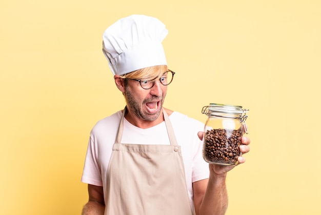 Blonde handsome chef  adult man holding a coffee beans bottle