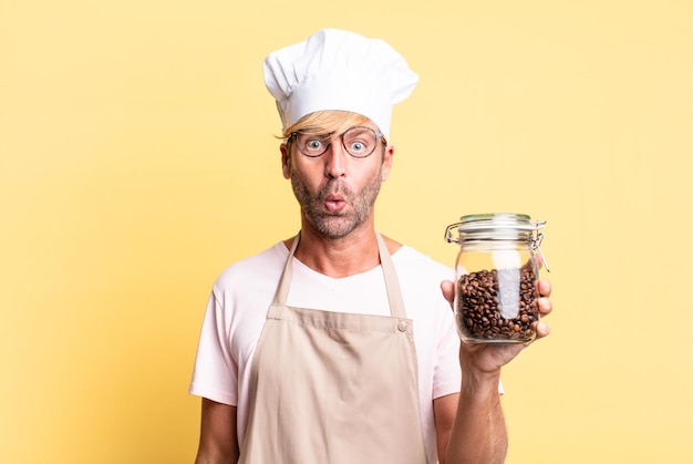 Blonde handsome chef  adult man holding a coffee beans bottle