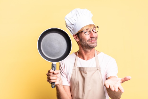 Blonde handsome chef  adult man holding a pan