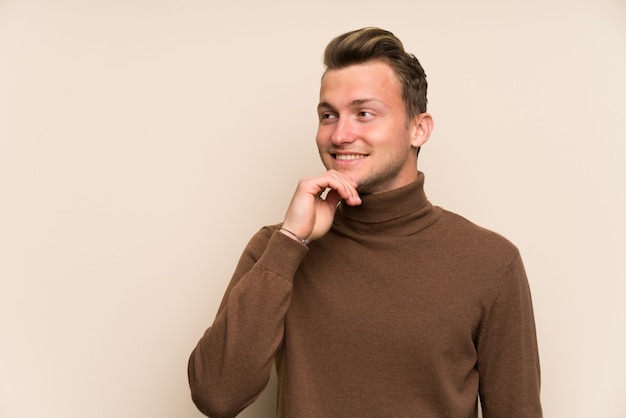 Blonde handsome man over isolated wall thinking an idea