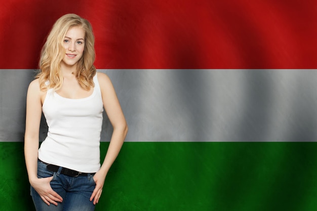 Фото Блондинка счастливая девушка с флагом венгрии на фоне путешествия или бизнес-концепции