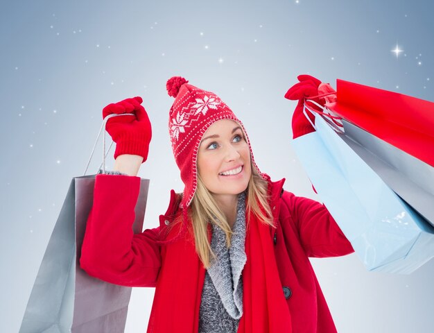 Blonde in winterkleren die het winkelen zakken houden