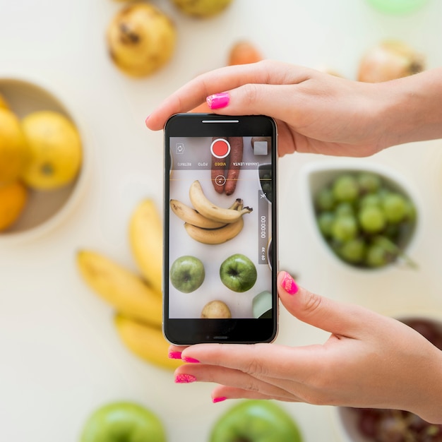 Foto blonde influencer neemt foto van fruit