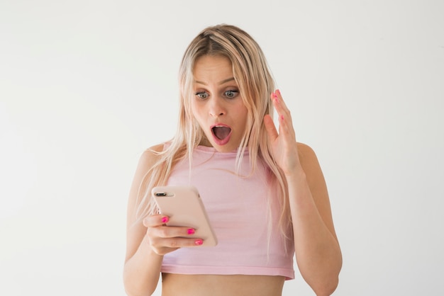 Foto influencer biondo che utilizza il telefono cellulare