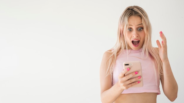 Photo blonde influencer using mobile phone