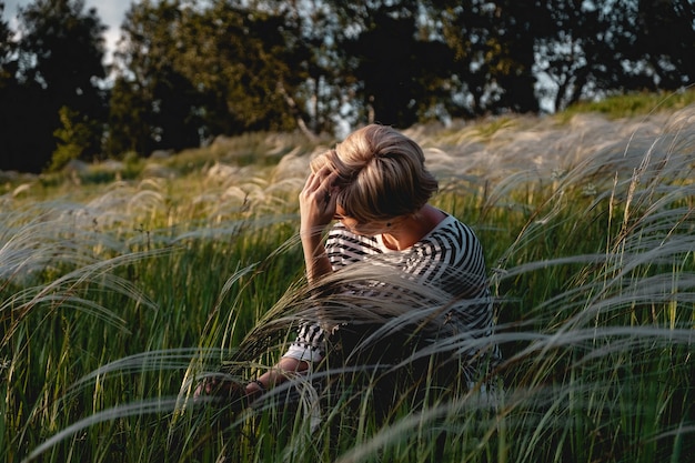 The blonde is resting in the field