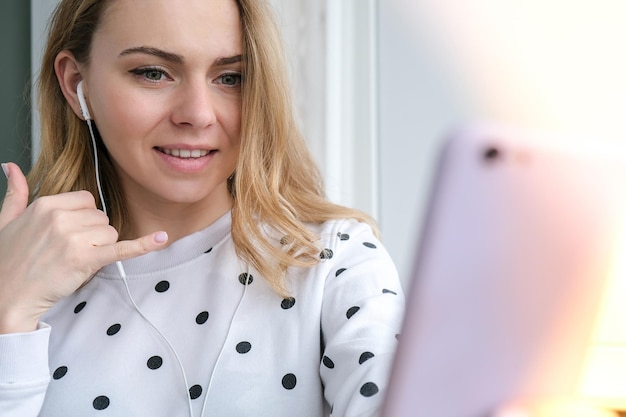 Foto blonde jong meisje neemt een selfie videogesprek online onderwijs werk thuis vrouw met telefoon