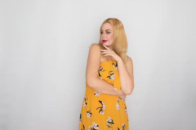 Blonde jonge vrouw in gele bloemen lente zomerjurk